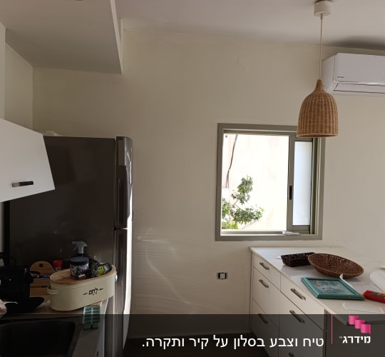 מטבח עם קיר צבוע, מקרר, כיור וחלון